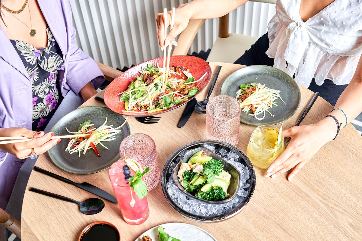 a woman sitting at a table with a plate of food